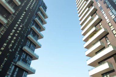 Milan, İtalya, Mart 2020. Milano 'da çarpıcı tonlara ve geometrik desenlere sahip iki modern eşsiz çok katlı binanın ön görüntüsü.