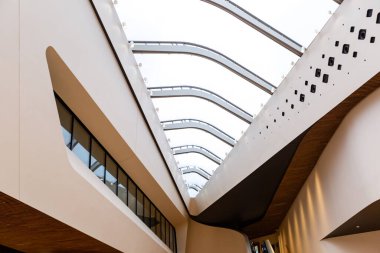 Milan, İtalya, Mart 2020. Bir ofis binasının ya da alışveriş merkezinin içi beyaz ahşap ile birleştirilmiş geniş pencereli modern bir tarzdır..