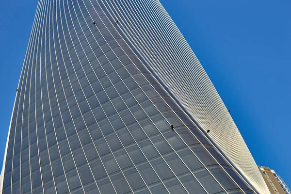 空に巨大な青い窓のある大きな建物の下の景色 — ストック写真