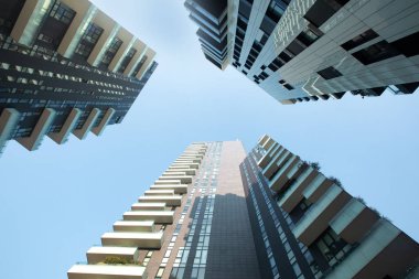 Milano 'da çarpıcı tonlara ve geometrik desenlere sahip üç modern, benzersiz çok katlı binanın ön görüntüsü.