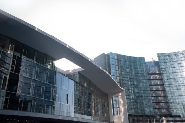 Binanın her tarafında mavi gökyüzüne bakan pencereleri olan modern yarı dairesel bir bina. 01.2020 Milano