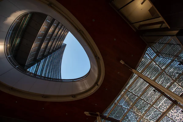 Het eivormige plafondraam kijkt uit op een gebouw met meerdere verdiepingen. Raamkleur donker hout. Milaan 01.20. — Stockfoto