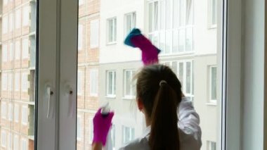 Güzel esmer kızlar sırtüstü durup temizlik yaparlar. Kız cama deterjan koyar ve yıkar..