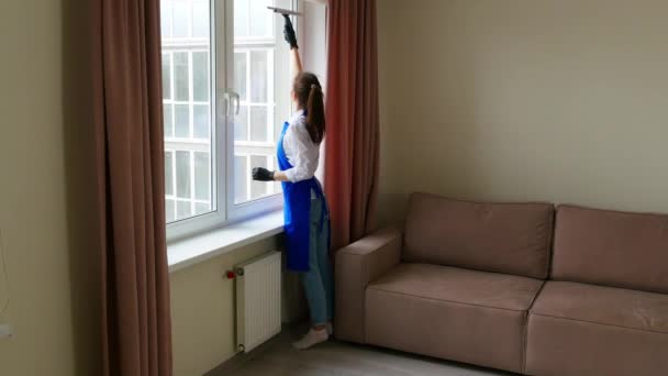 Gadis cantik berambut cokelat berdiri dengan punggung mereka dan melakukan pembersihan. Gadis itu mencuci jendela dengan kuas khusus untuk membersihkan jendela. — Stok Video