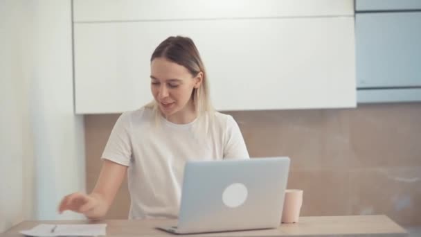 La joven sonriente está discutiendo el tema en línea. De buen humor. Gran oficina luminosa — Vídeo de stock