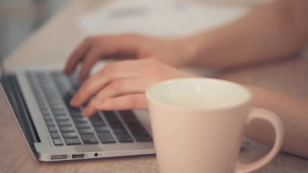 Escribiendo en línea. Trabaja como freelancer. Taza de café rosa. Copa Rosa al lado . — Vídeos de Stock