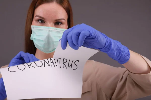 Žena slzný list papíru s nápisem "coronavirus" — Stock fotografie