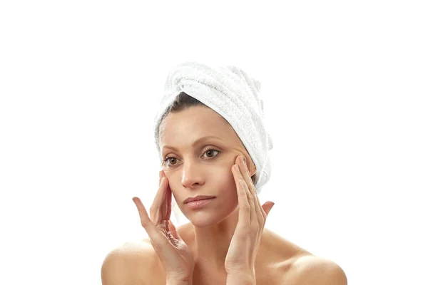 Piękna młoda kobieta z białym ręcznikiem na głowie i czystą, idealną skórą. Izolowane białe tło. — Zdjęcie stockowe