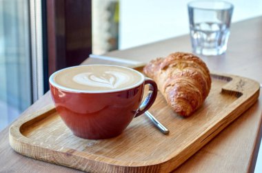 Büyük bir fincan kahve ve bir kruvasan..