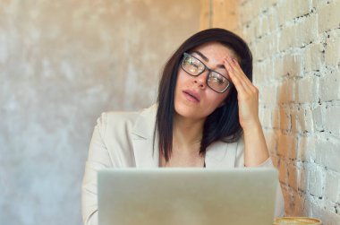 Çevrimiçi serbest çalışan beyaz tuğlalı duvarları olan modaya uygun bir kafede çalışıyor. Güzel esmer kız..