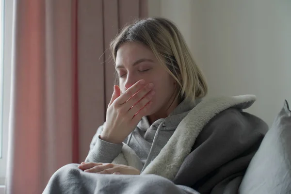 Zieke jonge vrouw niezen in weefsel — Stockfoto