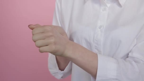 Proper rubbing of moisturizer into female hands on a pink background. — Stock Video