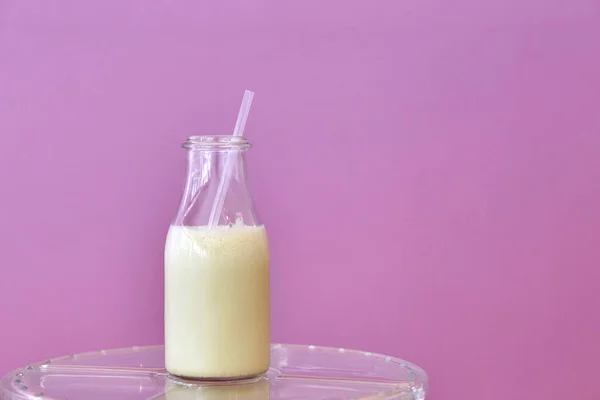 Leche en una botella de vidrio con paja . —  Fotos de Stock