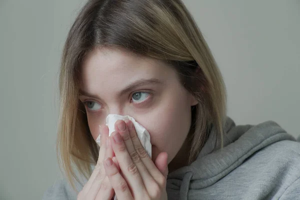 Un primer plano de mujer sonándose la nariz — Foto de Stock