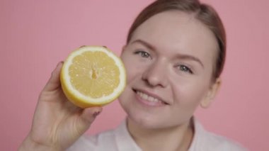 Sarı limonu makyajsız bir kızın ellerinde kes..