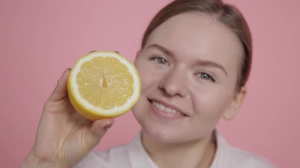 Gelbe Zitrone in die Hände eines Mädchens ohne Make-up schneiden. — Stockvideo