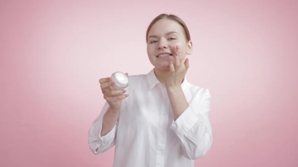 Natural hidratante branco na bochecha de uma menina bonita . — Vídeo de Stock