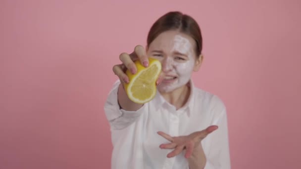 Το κορίτσι προσπαθεί να πιέσει το χυμό λεμονιού και σφίγγει σφιχτά το χέρι της. — Αρχείο Βίντεο