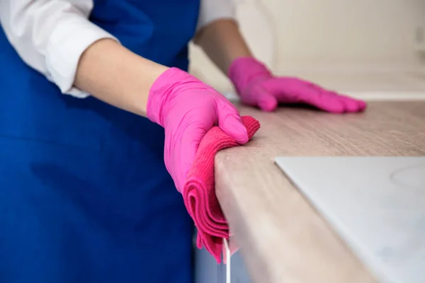 Meisje in roze rubberen handschoenen wast de keuken. — Stockfoto