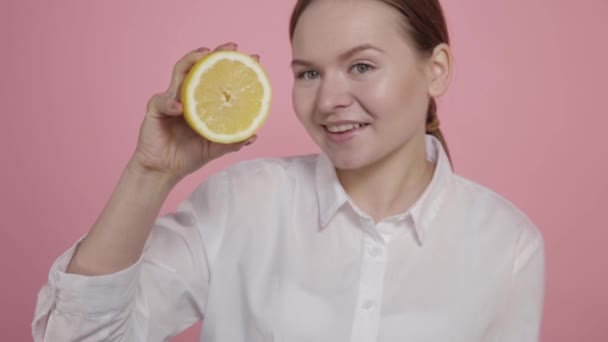 Розрізати жовтий лимон в руках дівчини без макіяжу . — стокове відео