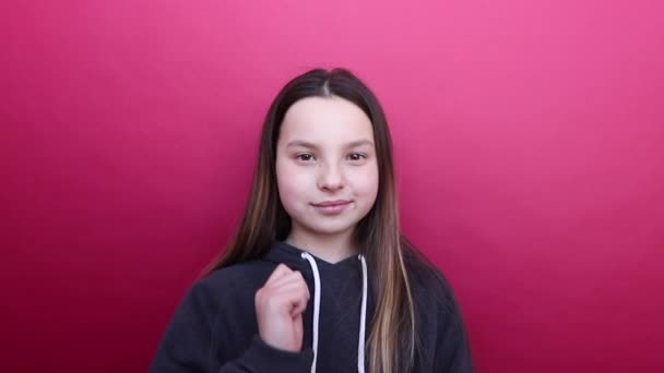 Beautiful girl pointing at the camera, showing the cool sign and winks. — Stock Video