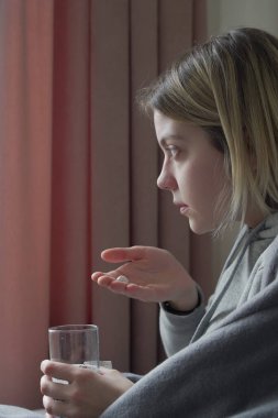 Pembe arka planda hap alan genç bir kadın.