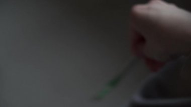 Battaniyeye sarılı bir kız termometrenin sıcaklığını düşürüyor. Orvi, koronovirüs, grip, akut solunum hastalığı belirtileri..