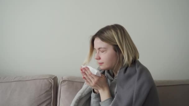 Una chica con ojos cansados está enferma y estornuda. Síntoma de Orvi, coronovirus, gripe, enfermedad respiratoria aguda, alergia . — Vídeo de stock