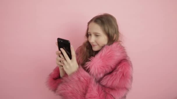 Joven hermosa chica lee mensajes en las redes sociales y responde mensajes en un teléfono móvil negro . — Vídeos de Stock
