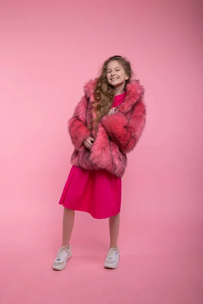 Modelo de moda menina em roupas na moda, casaco de pele rosa claro em um fundo rosa no estúdio. Estilo . — Fotografia de Stock