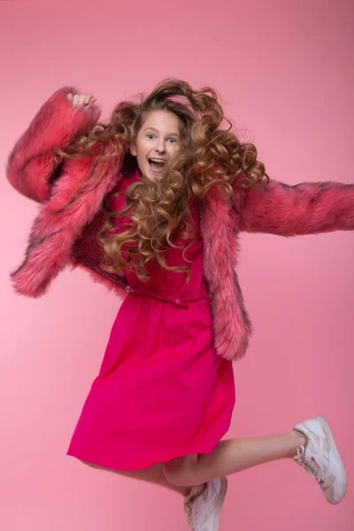 Modelka dziewczyna w modne ubrania, jasnoróżowy futro płaszcz na różowym tle w studio. Rodzaj. — Zdjęcie stockowe