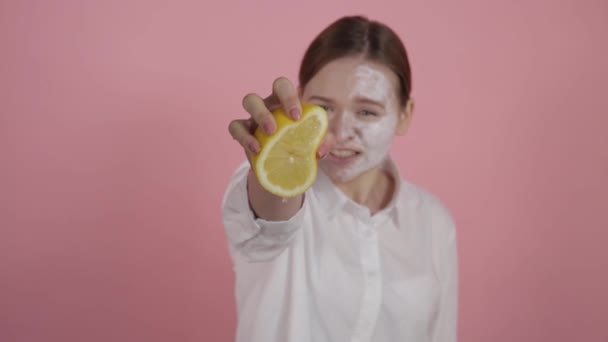 Der Begriff Naturkosmetik. Ein Mädchen mit natürlicher Schönheit und ohne Make-up presst Saft aus einer Zitrone. — Stockvideo