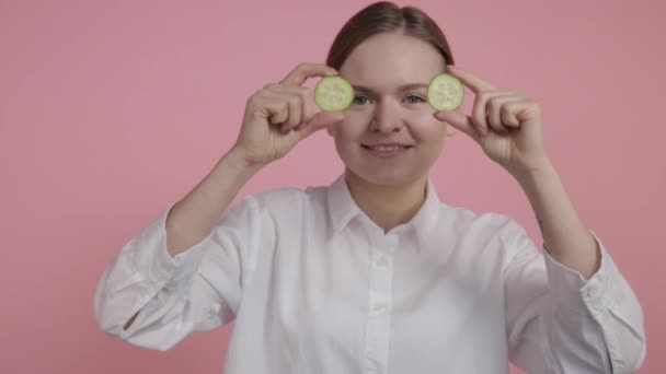 Egy fiatal lány két nagy sárga facsarja a gyümölcslevet, és nézi, hogyan folyik a gyümölcslé.. — Stock videók
