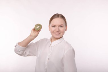 Makyajsız bir kızın portresi. Parlak meyvelerin ellerinde.