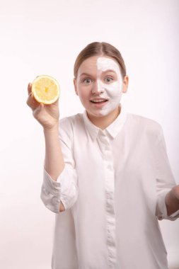 Suratı şaşkın, elinde meyve tutan bir kız..