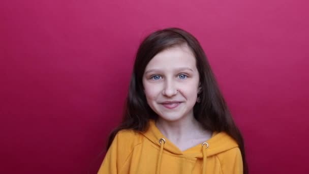 Joyful girl brunette with blue eyes in orange shows a bike with your hands direction. Direction left. — Stock Video