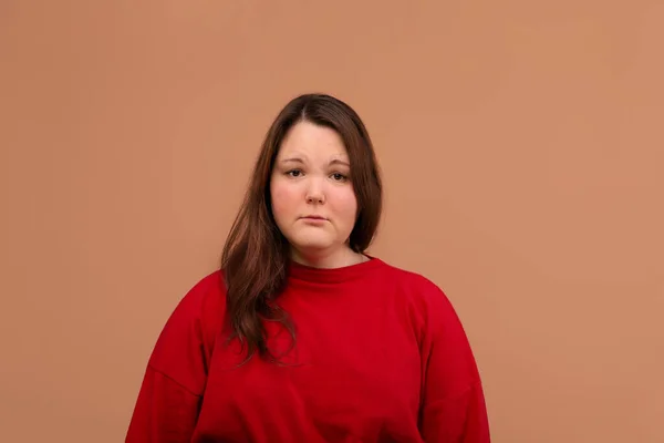 Een droevige uitdrukking van de jonge meisjes gezicht. Helder rood jasje. — Stockfoto