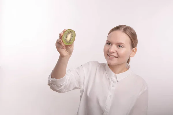 Nahaufnahme Kiwi-Frucht in den Händen eines schönen Mädchens. — Stockfoto