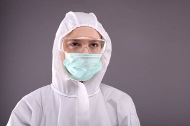 Koruyucu kostüm, gözlük ve maske takan genç bayana yakın durun.