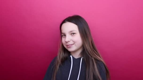 Happy girl dancing and moving the body. Nice smile. Pink background. — Stock Video