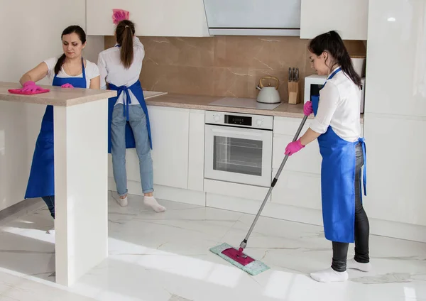 As raparigas estão a limpar a casa. A rapariga lava o chão. Limpeza de casa profissional . — Fotografia de Stock