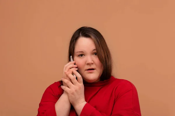 Una hermosa joven está hablando en un teléfono móvil con una mirada excitada . — Foto de Stock