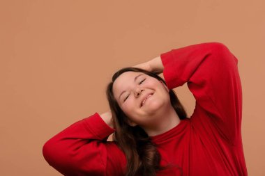 Güzel, gülümseyen bir kız ellerini başının arkasına koydu..