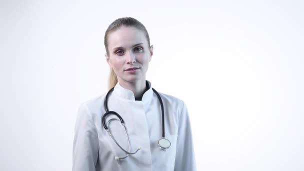 Молодая девушка-доктор показывает пальцем вниз . — стоковое видео