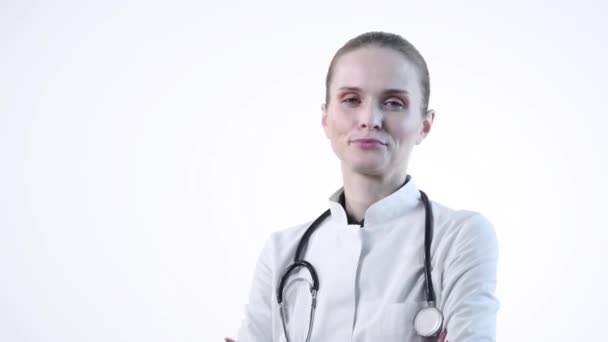 Selbstbewusste schöne Ärztin blickt in die Kamera und lächelt. — Stockvideo