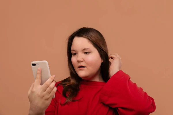Ein junges Mädchen blickt in ihr Handy. Überraschtes Gesicht. — Stockfoto