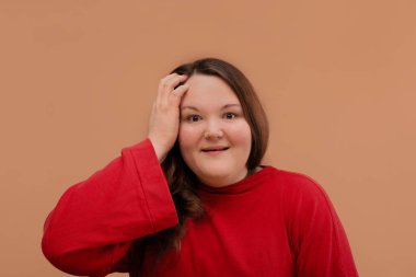 Şaşırmış bir kız kameraya bakar. Güzel, dolu bir kız..