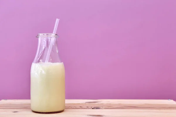 Mjölk i glasflaska med sugrör. — Stockfoto