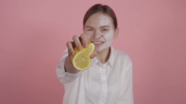 Doğal kozmetik konsepti. Doğal güzelliği olan ve makyajsız bir kız limondan meyve suyu sıkar..