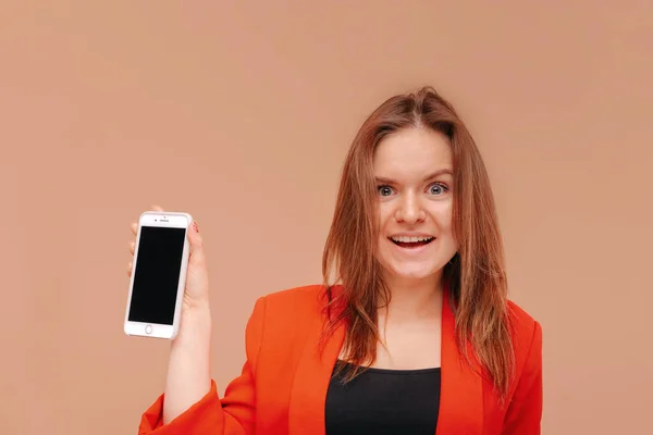 Una chica joven muestra una pantalla de teléfono inteligente en blanco . — Foto de Stock